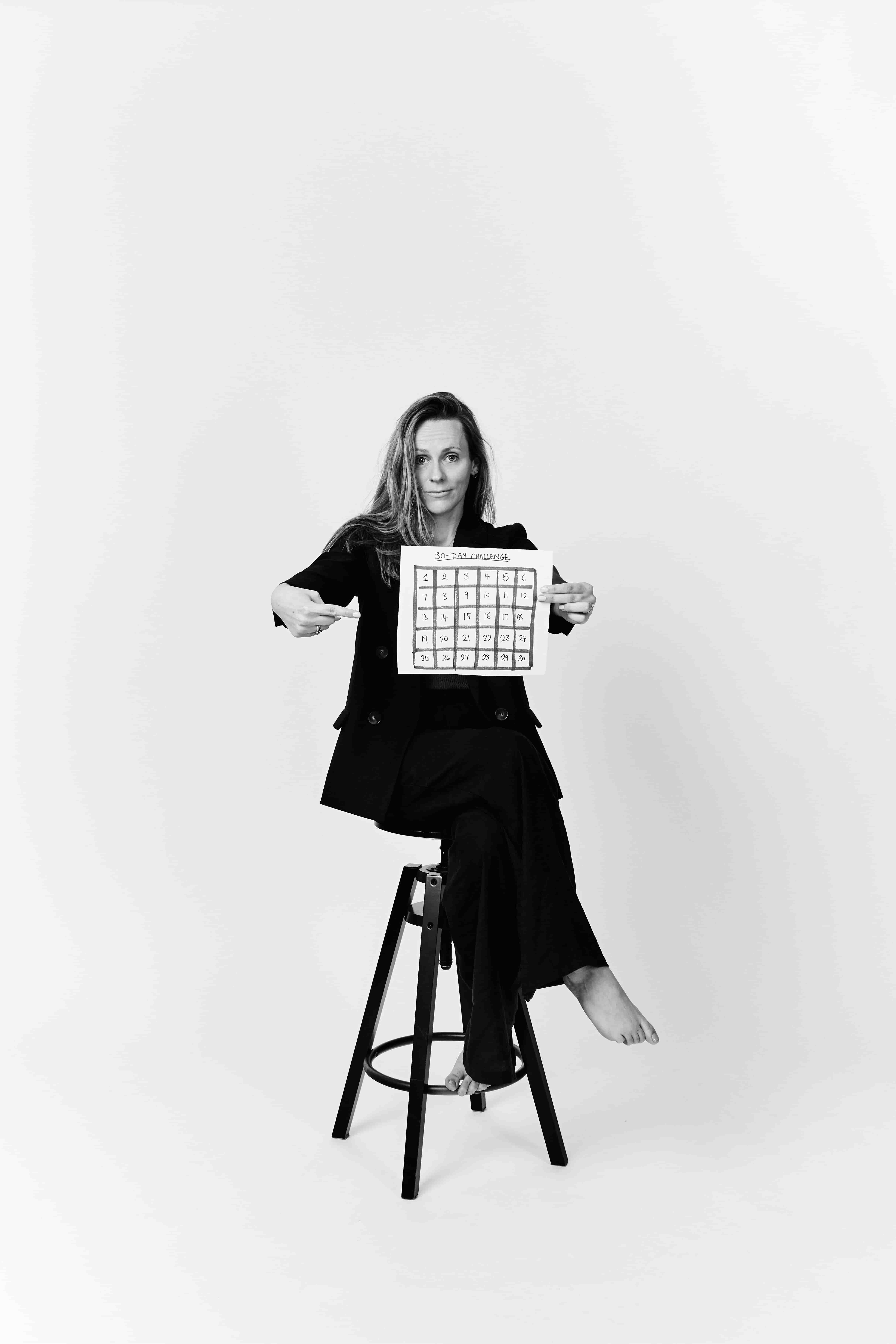 Chloe pointing at a hand-drawn thirty-day challenge grid
